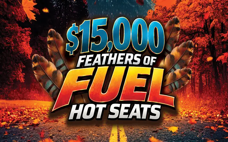 $15,000 Feathers of Fuel Hot Seats promotional logo featuring bold blue, orange and gold lettering surrounded by feathers against a scenic autumn road lined with vibrant red and orange trees.