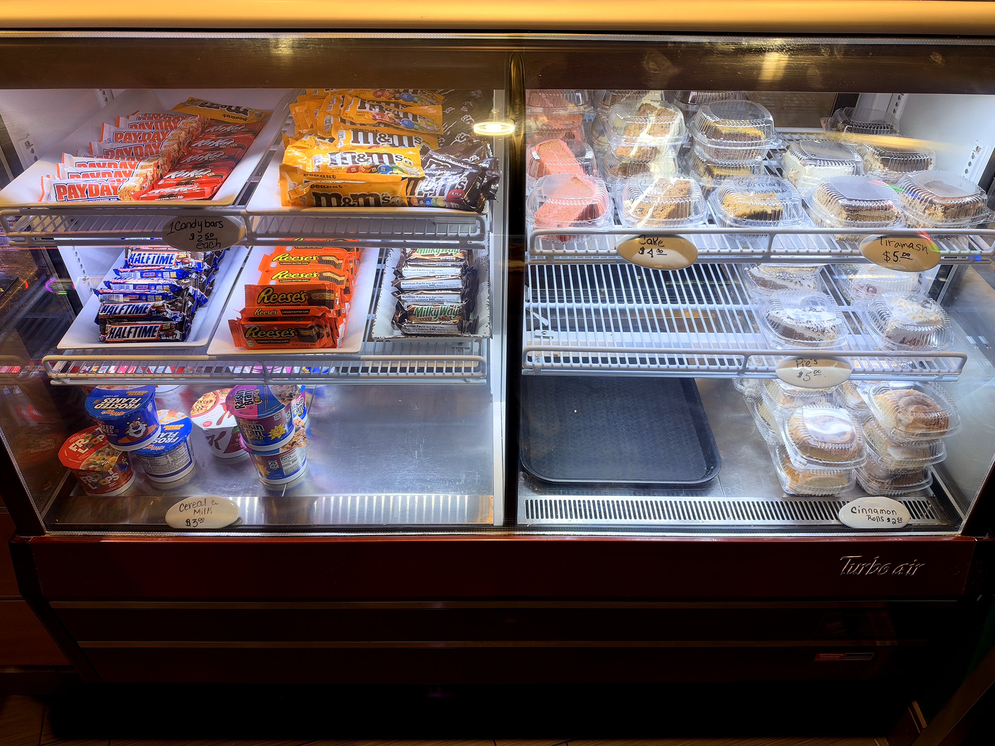 Refrigerated display case featuring candy, cakes, pastries, and snacks at the River Bend Casino Deli
